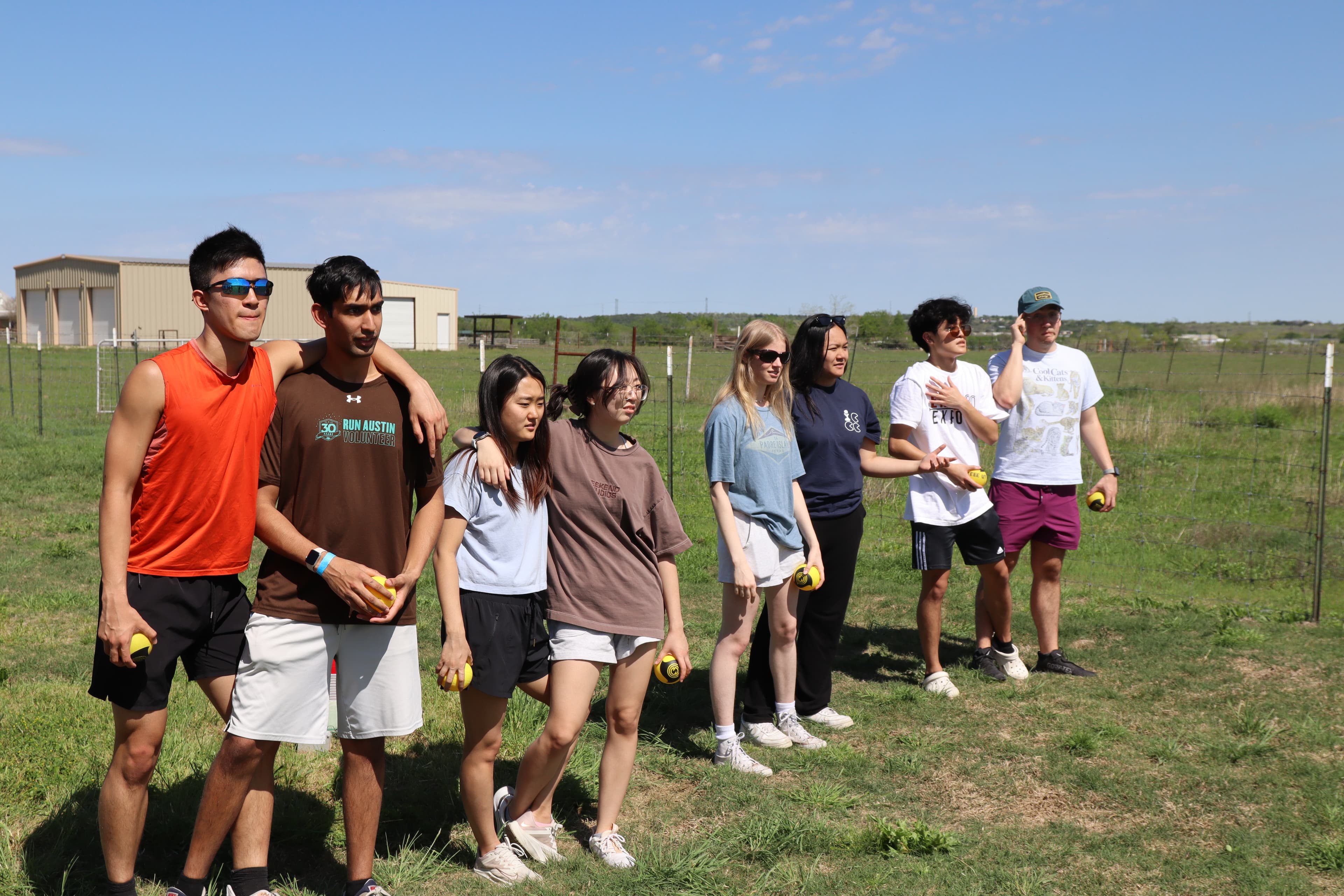 Members listening to activity instructions in pairs on field