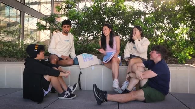 Members in IEEE merch sitting down, laughing and talking to one another